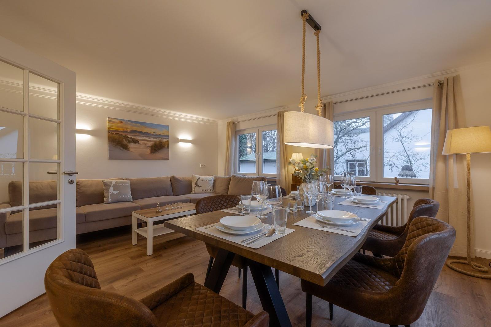 Essbereich mit Tisch und Stühlen, Wohnbereich mit Sofa und Fenster