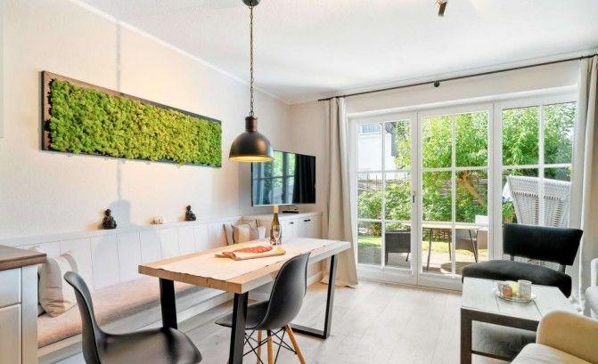 Essbereich mit Tisch, Stühlen und TV. Durchgang zur Terrasse mit Gartenansicht.