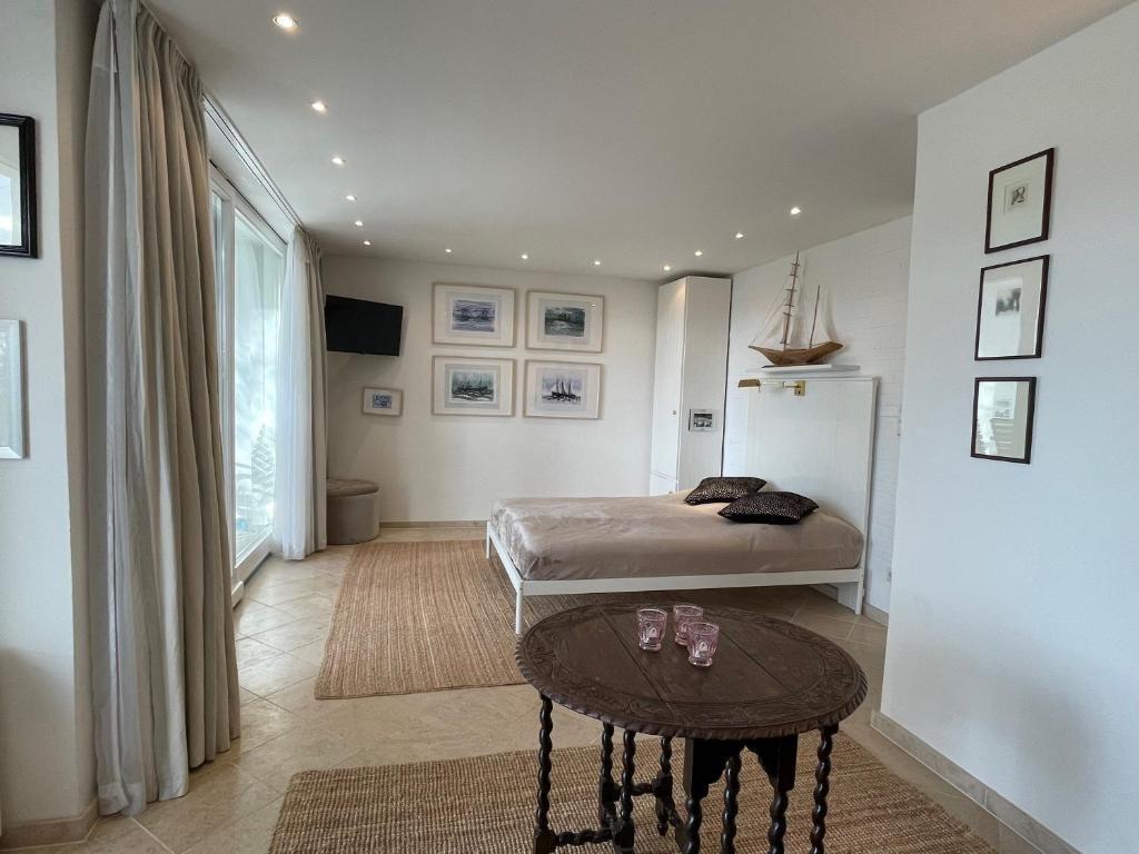 Schlafzimmer mit Bett, Tisch und Fenster. Wanddekoration und Möbel sind sichtbar.