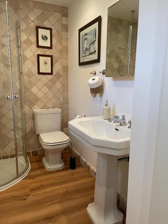Badezimmer mit Dusche, Toilette und Waschbecken auf Sockel
