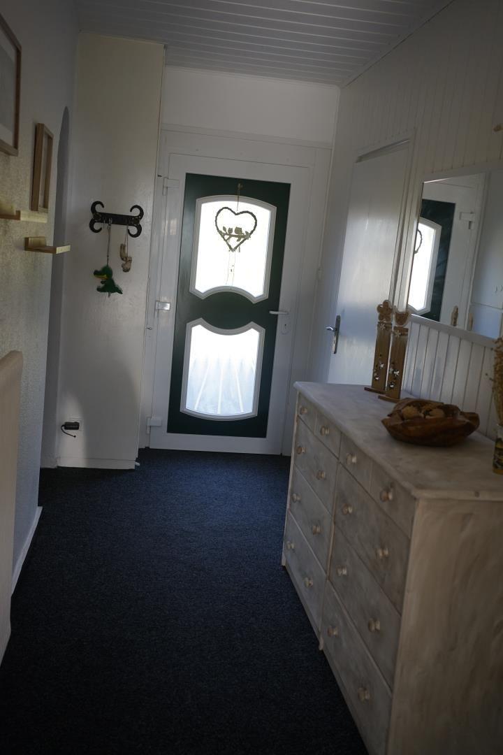 Entrance area with door, dresser, and mirror on the wall.