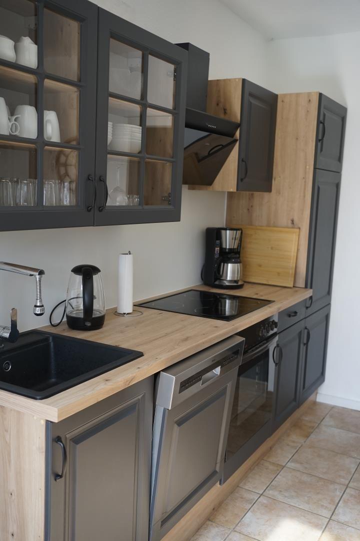 Kitchen with dark cabinets, wooden surfaces, and modern equipment.