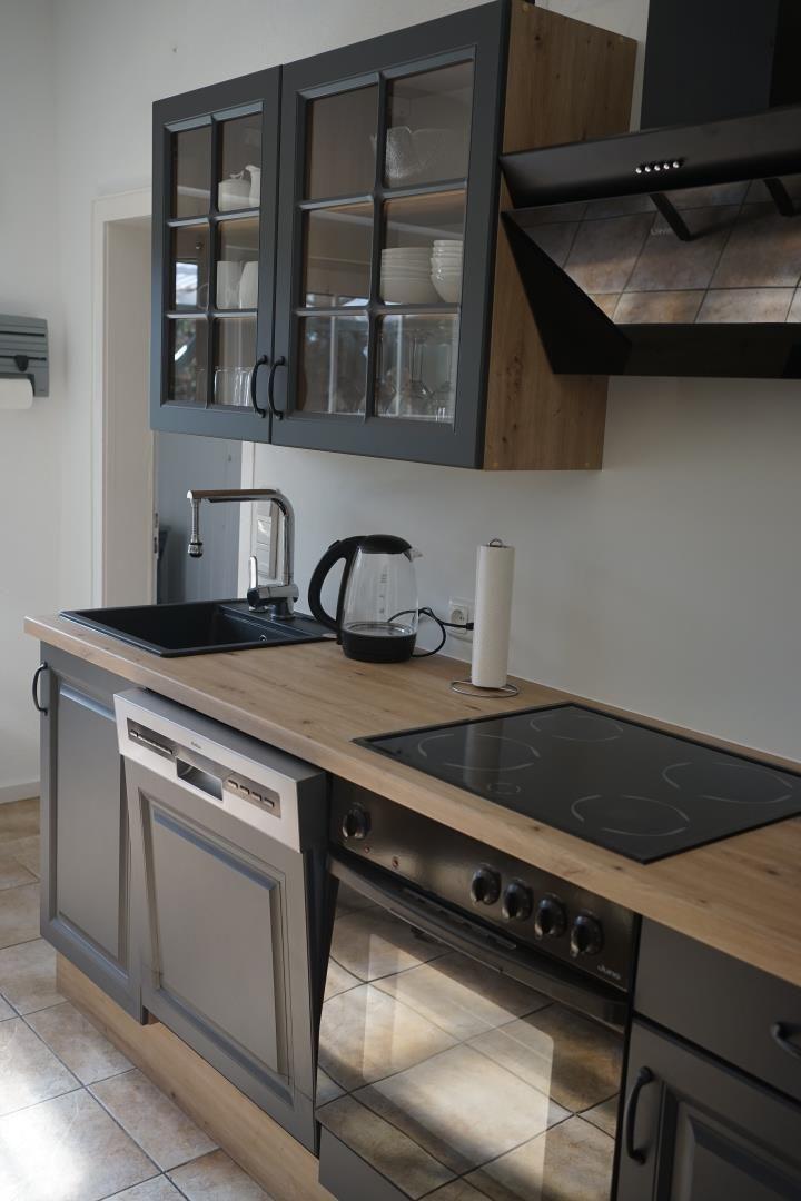 Kitchen with range hood, sink, cooktop, and dishwasher.