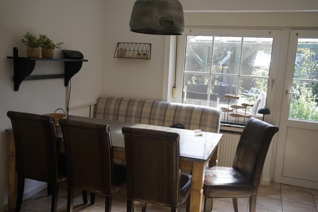 Dining room with table, four chairs, and window to terrace.