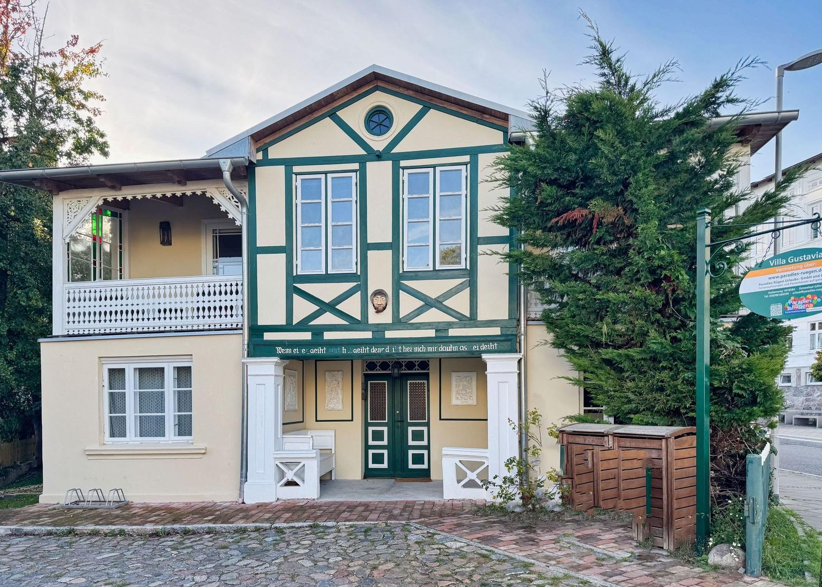 Fassade einer Villa mit Balkon und grüner Tür