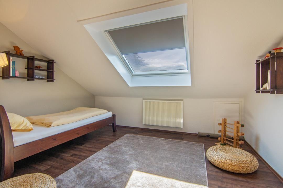 Schlafzimmer mit Dachschrägen, Dachfenster und Holzboden