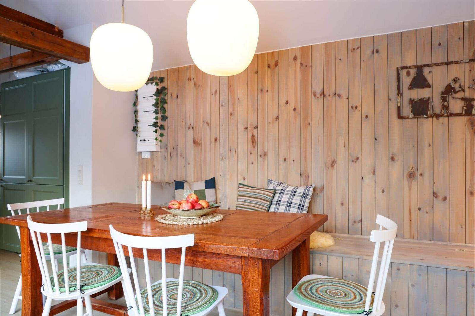 Dining room with wooden wall, table, chairs, and side table.