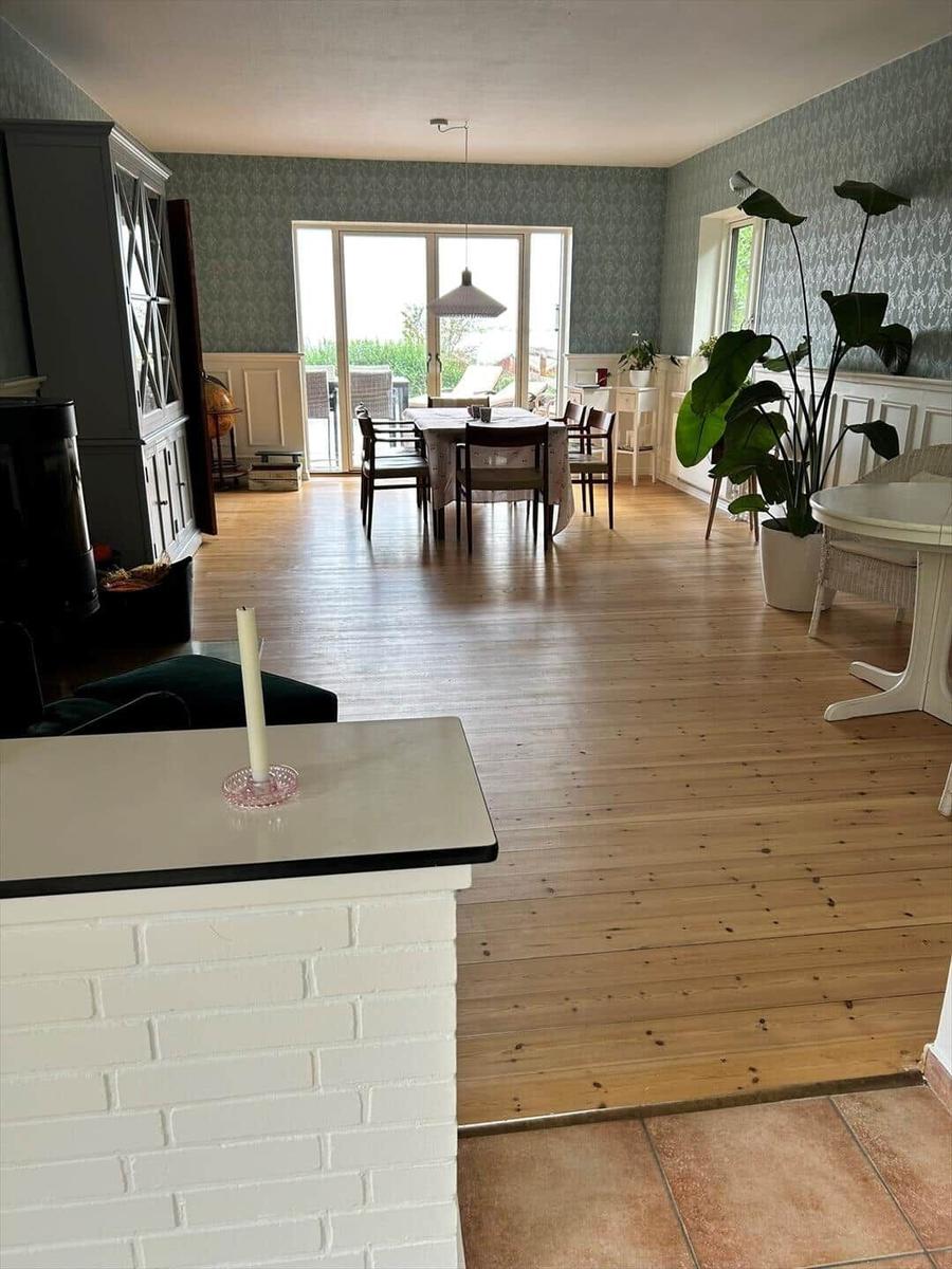 House with dining room, wooden floor, and large window to terrace.