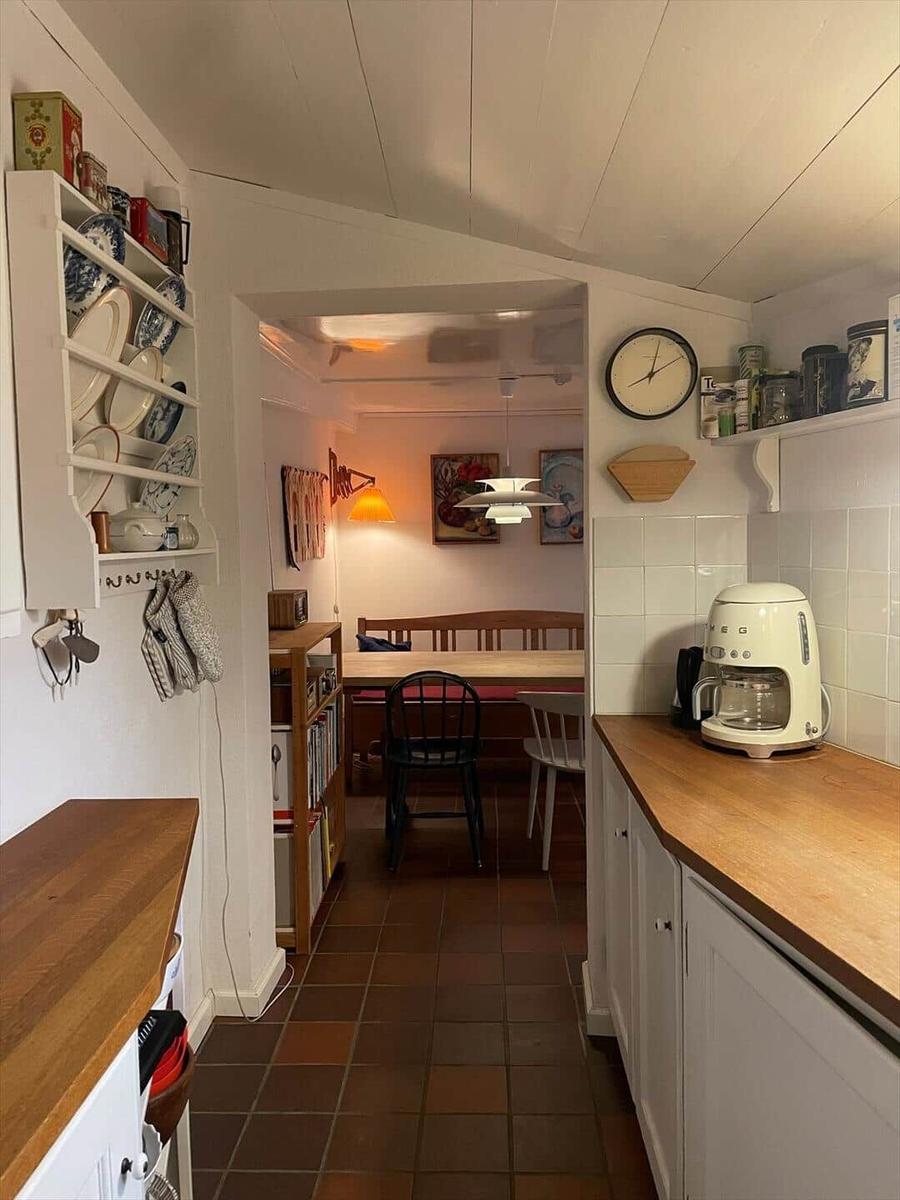 Kitchen with wooden countertop and dining area in the background.