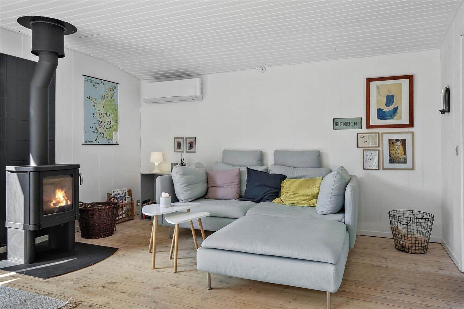 Ein Wohnzimmer mit einem Kaminofen, einem Sofa und Wanddekoration.