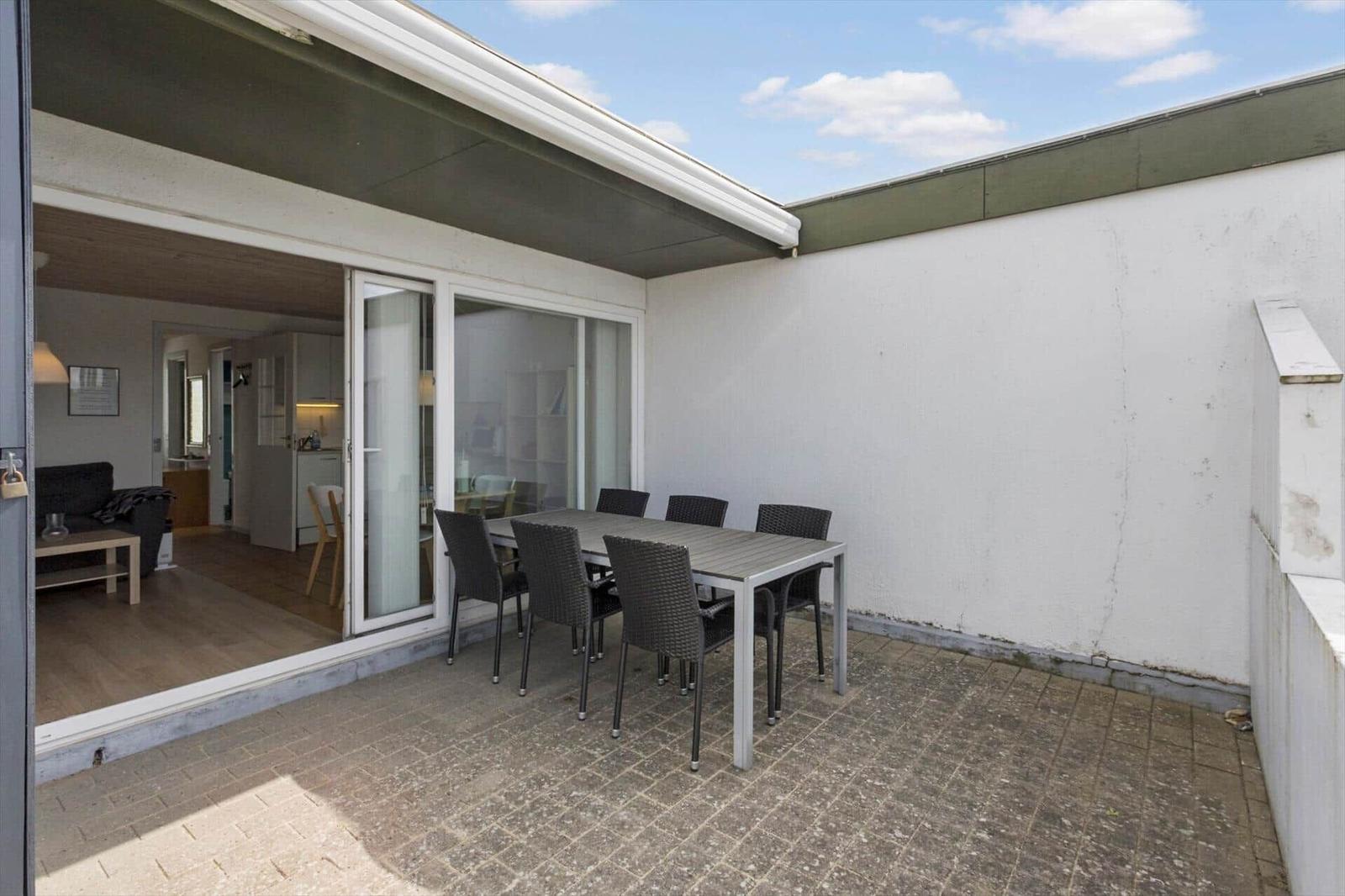 Terrasse mit Tisch und Stühlen, Blick ins Innere des Hauses.