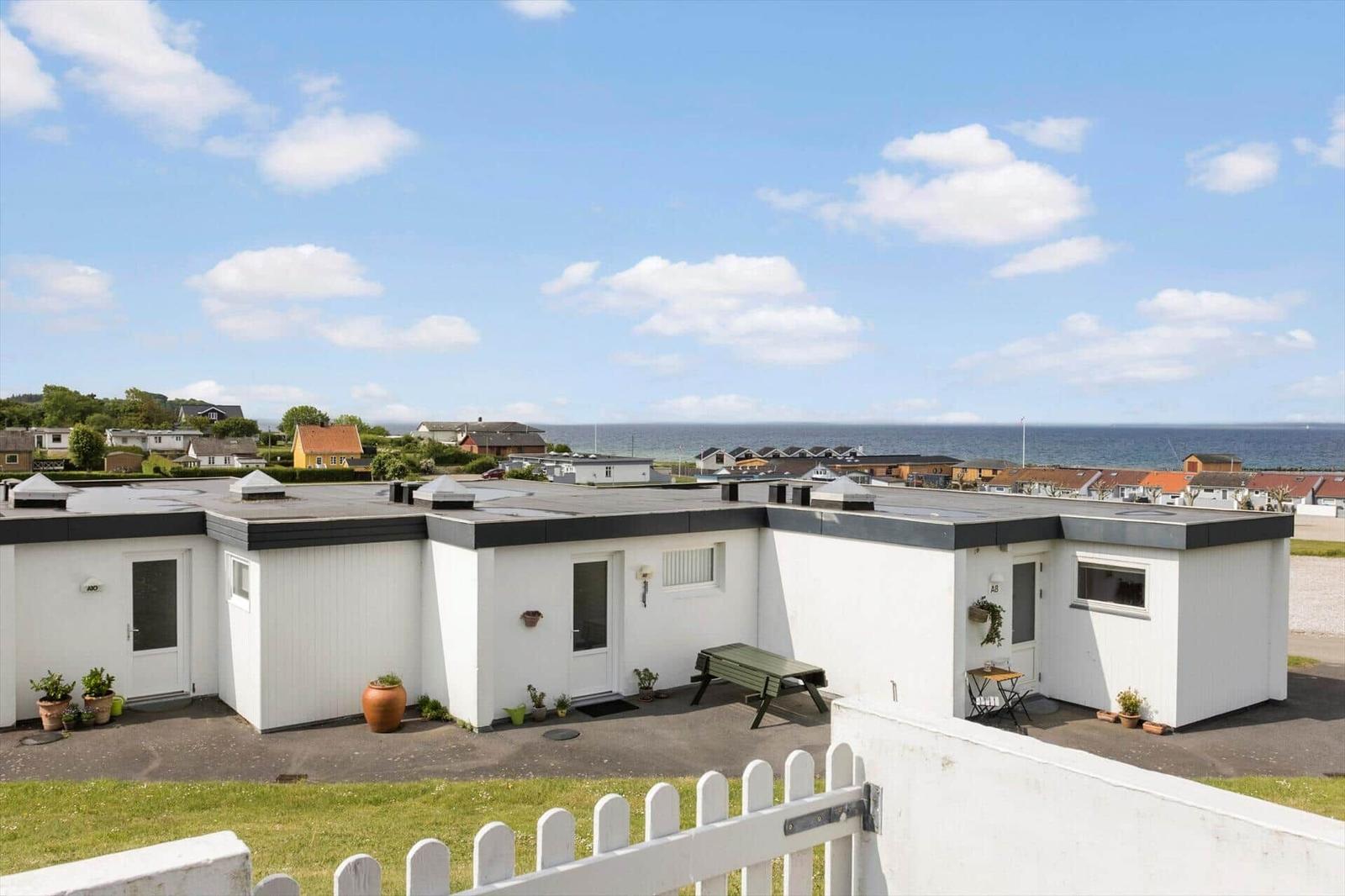Wohnung mit Blick auf Meer und Strand. Außenbereich mit Tisch und Bank.