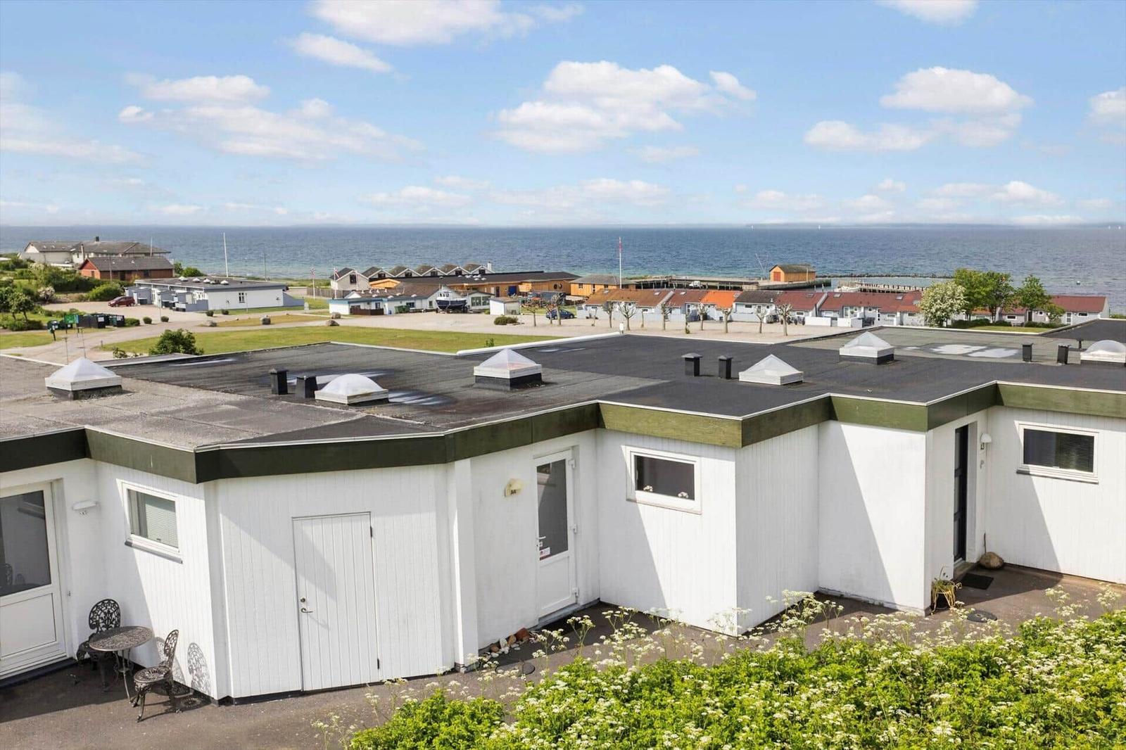 Wohnung mit Blick auf Meer und Strand. Weiße Fassade, Terrasse und Garten.