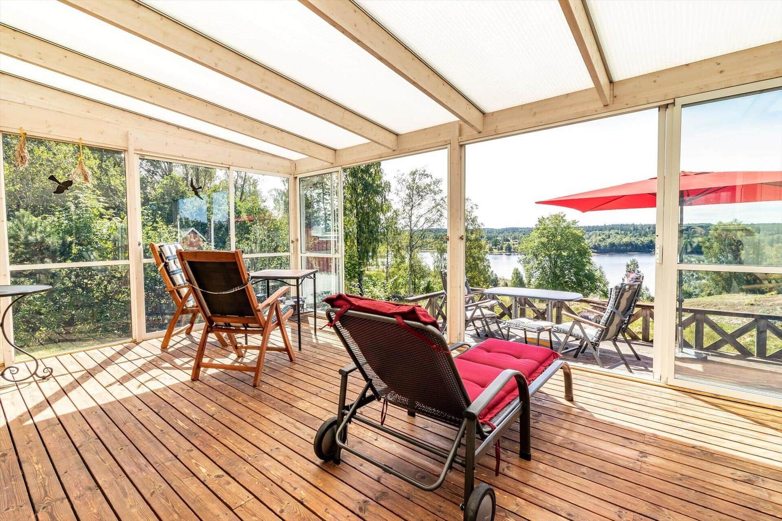 Terrasse mit Sitzgelegenheiten und Blick auf einen See.