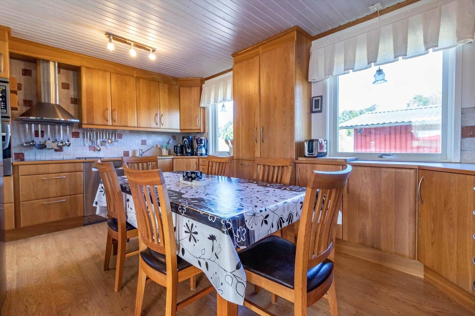 Küche mit Essbereich, Holzmöbel und Fensterblick auf roten Schuppen.