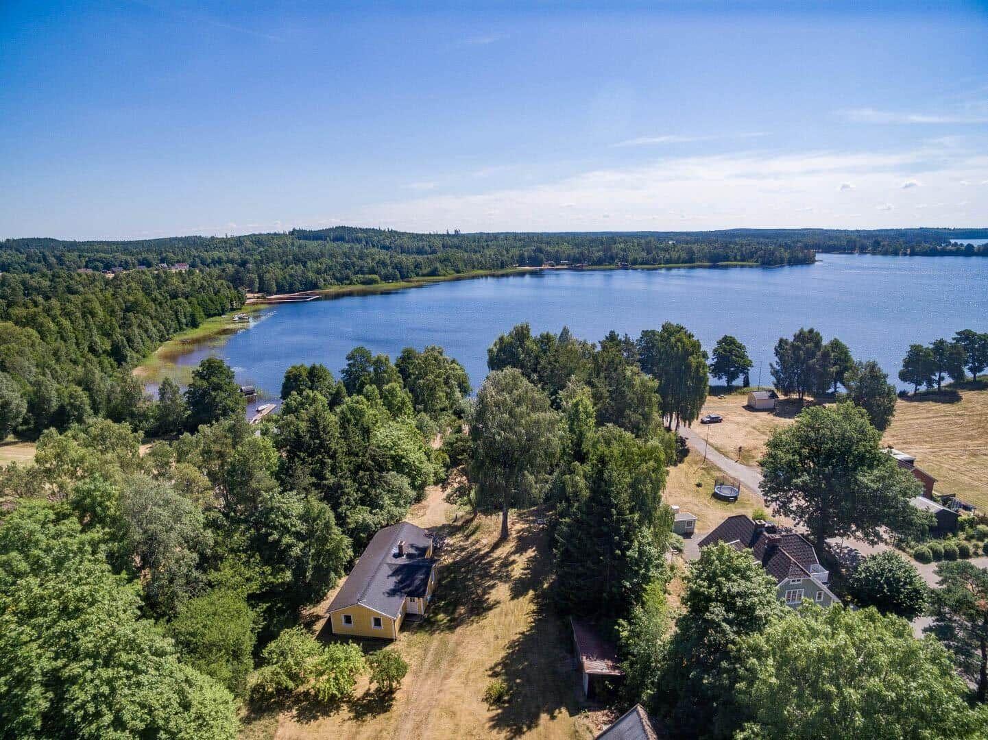 Haus am See mit Wald und freiem Blick auf das Wasser.