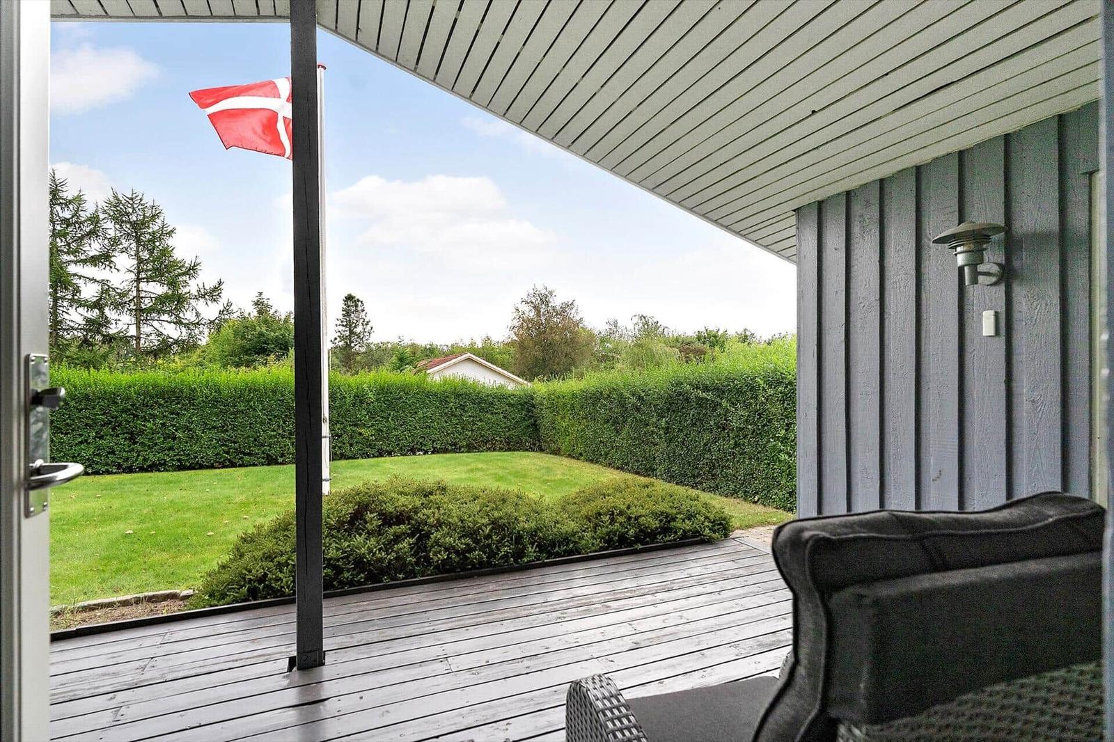Terrasse mit Blick auf grünen Garten und dänische Flagge