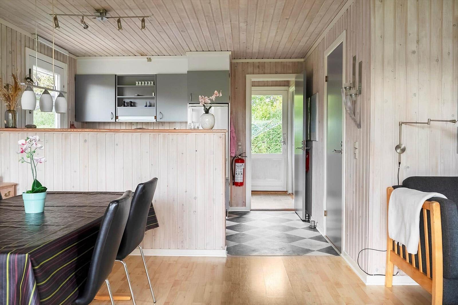 Küche mit Essbereich und Wohnbereich mit Holzwand und -decke.
