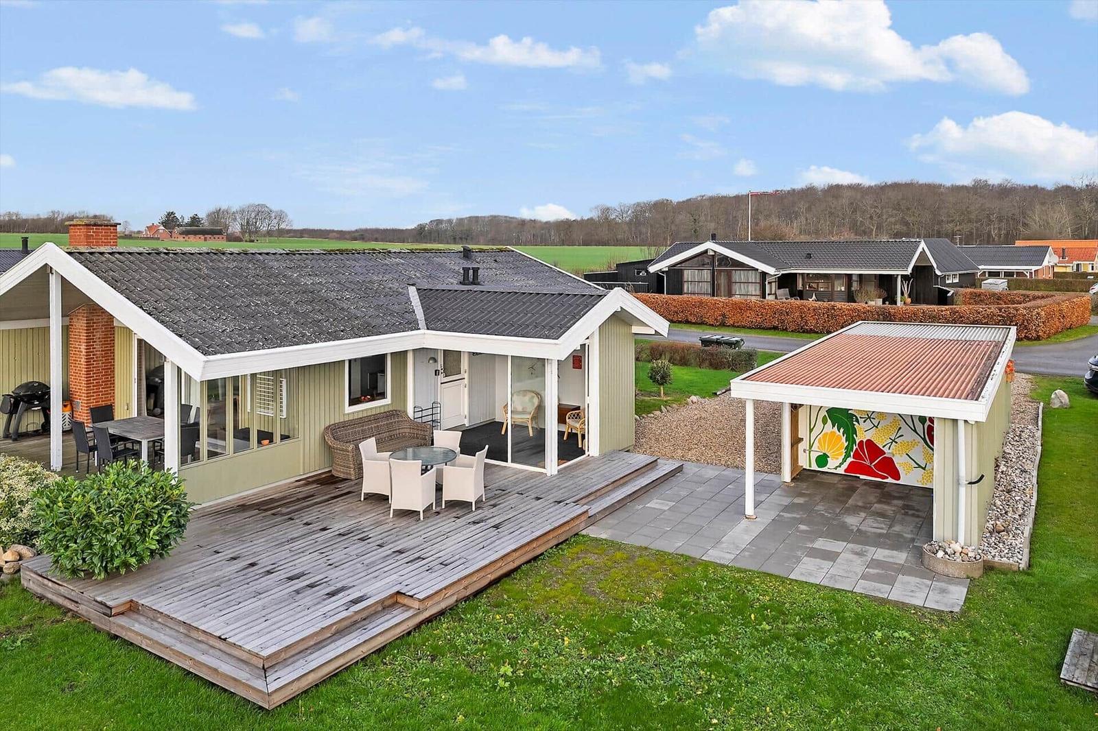 Moderne Villa mit Terrasse, Grillplatz und Garten. Garage mit buntem Wandbild.