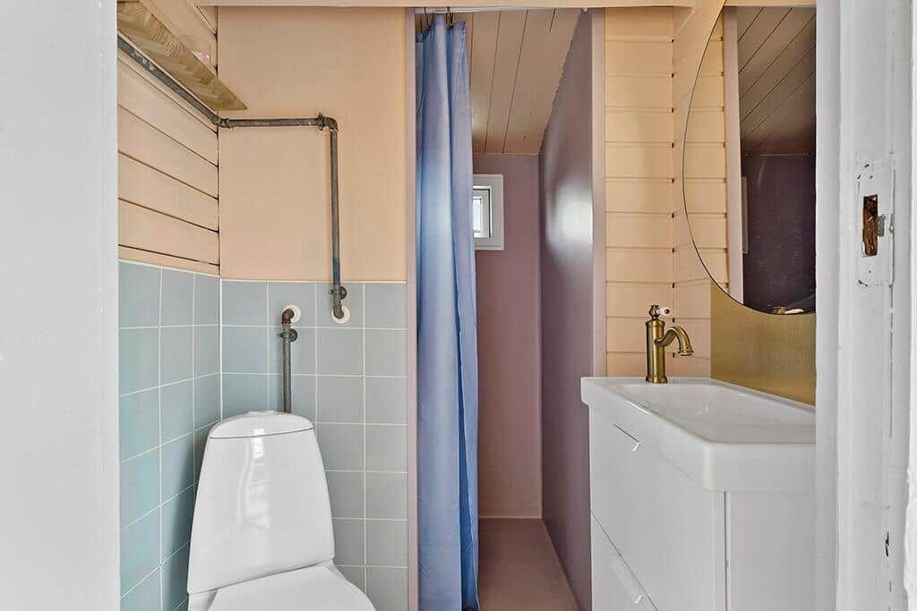 Bathroom with toilet, sink, and shower with curtain.