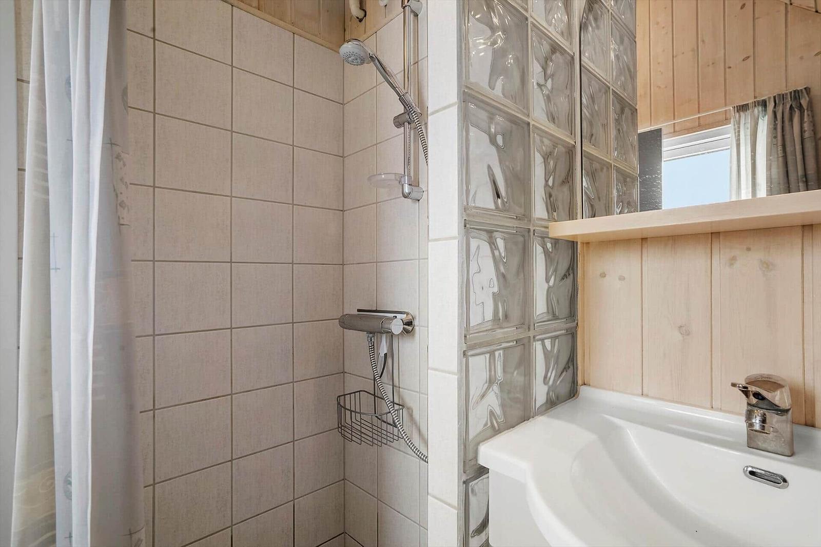Bad mit Dusche, Waschbecken und Glasblockwand