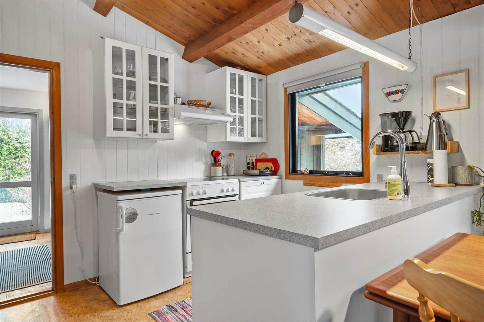 Kitchen with countertop, sink, refrigerator, and window.