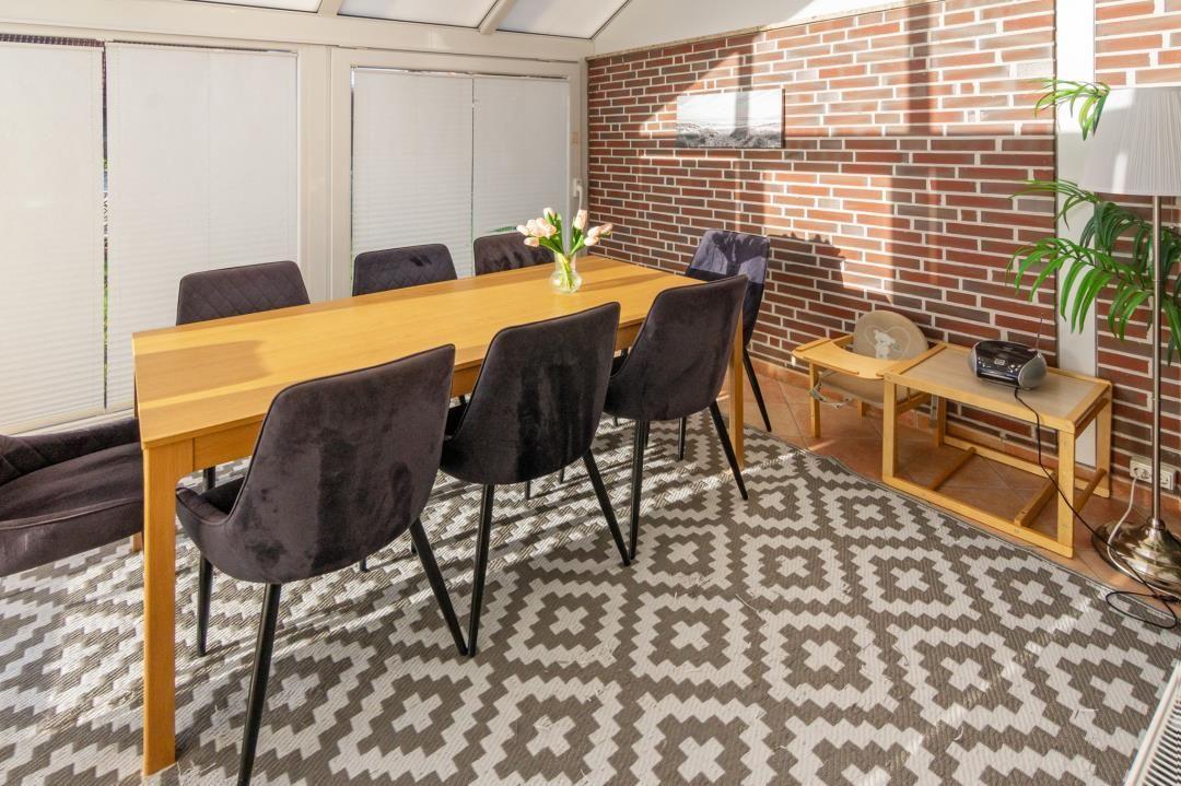 Dining room with wooden table, chairs, and patterned rug