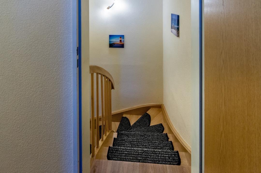 Wooden staircase with carpet and wall pictures