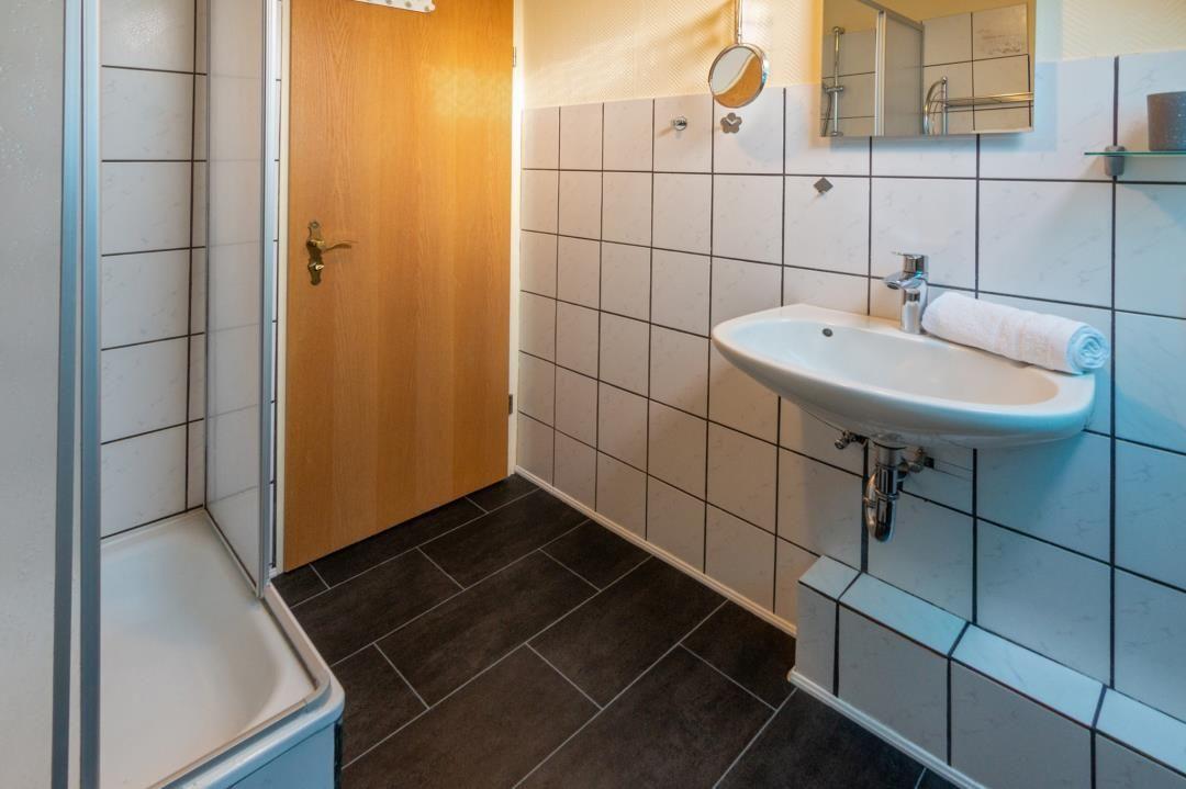 Bathroom with shower, sink, and mirror