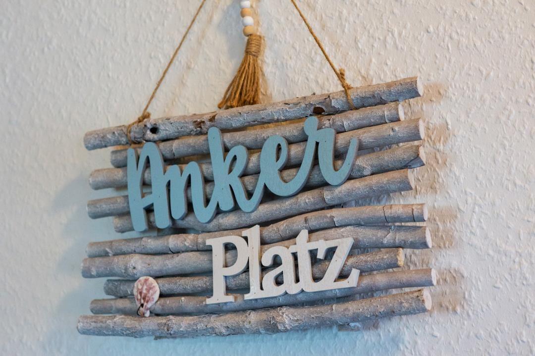 Sign made of branches with the words Anker Platz and shell