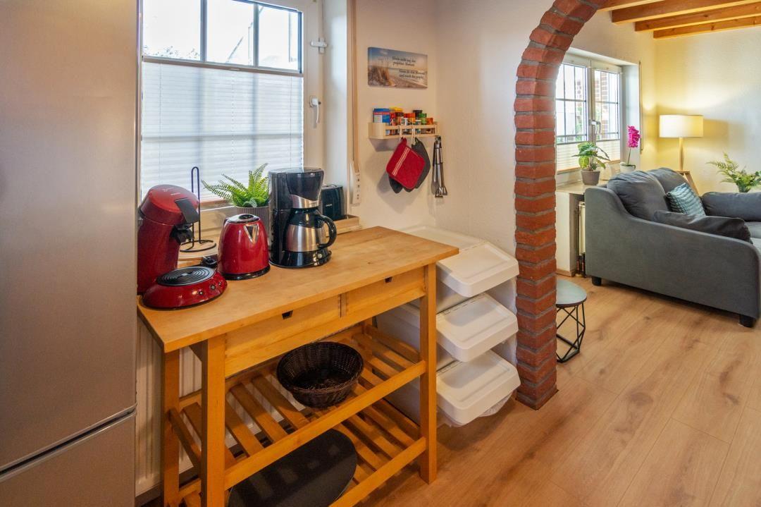 Kitchen area with countertop, coffee maker, and view of living room.
