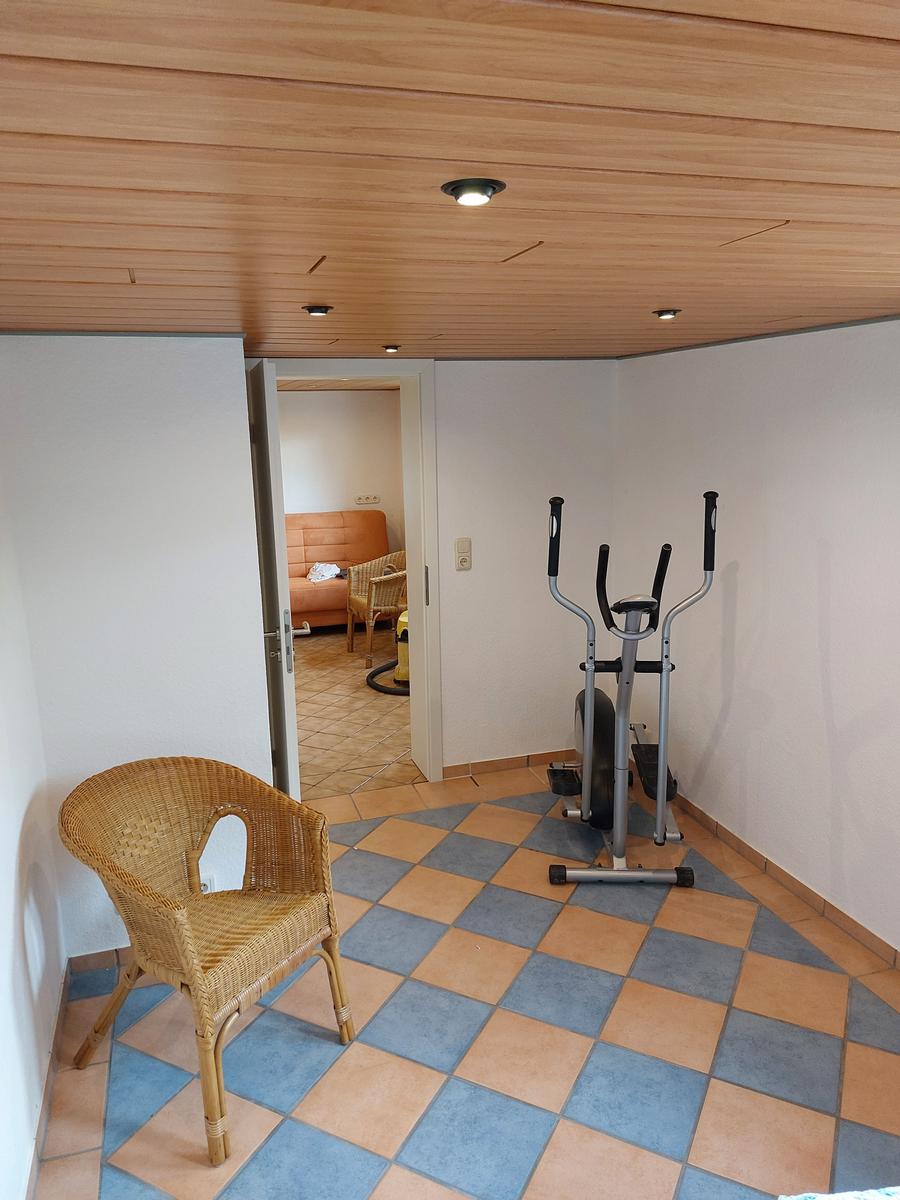 Fitnessraum mit Kletterwand und Sitzgelegenheit
