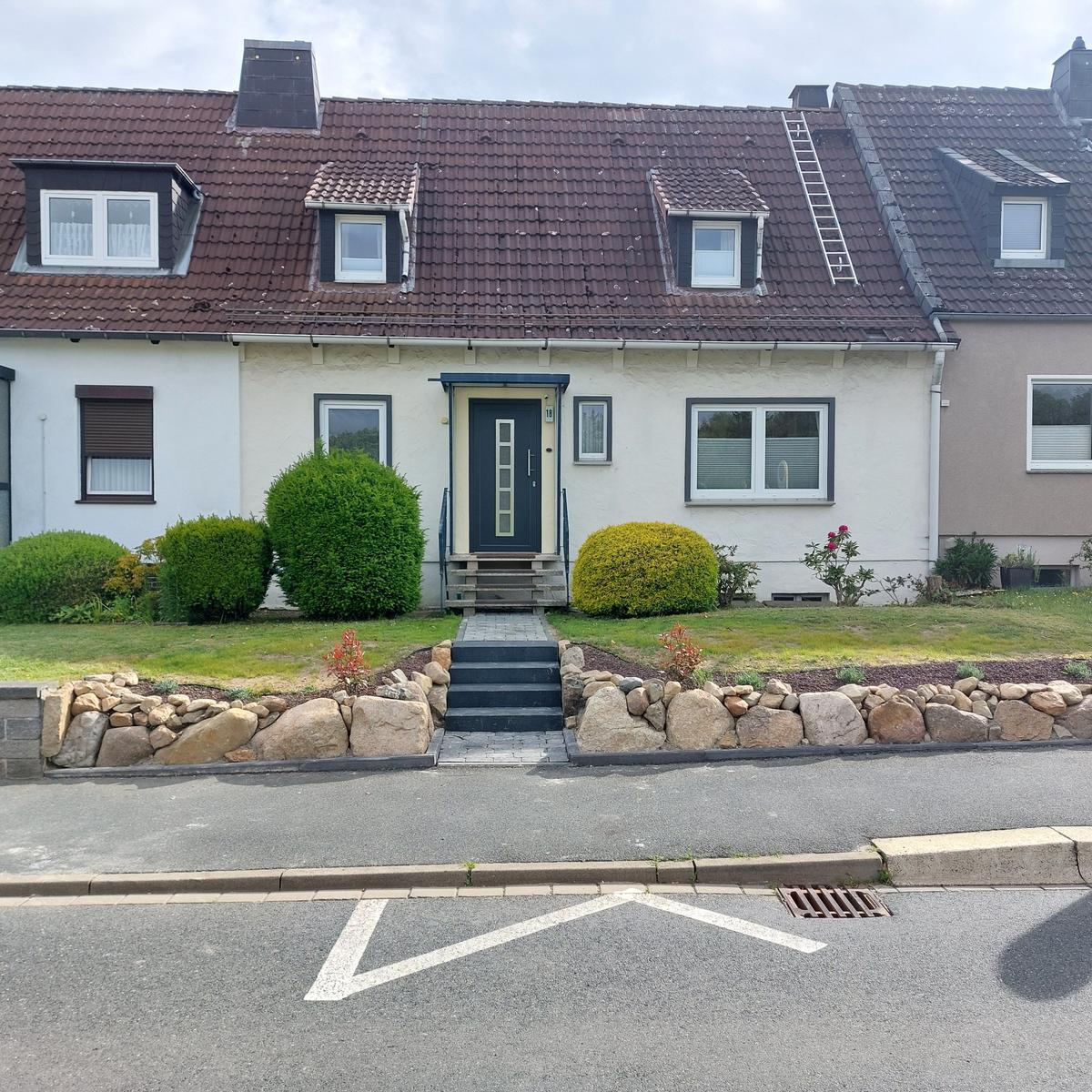 Haus mit Dachfenstern, Vorgarten und Steinterrasse