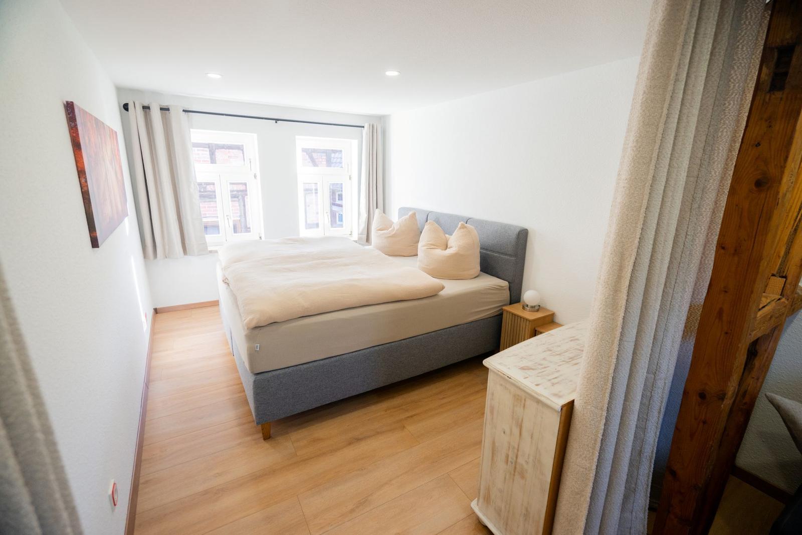 Schlafzimmer 1 der Ferienwohnung Bergmoment in Blankenburg Harz mit 180 cm Boxspringbett und 160 cm Klappcouch.