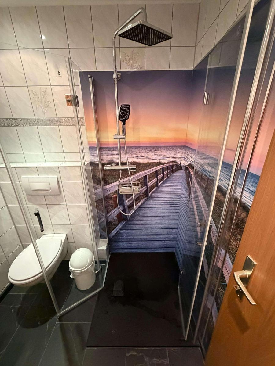 Moderne Dusche mit idyllischer Fotorückwand