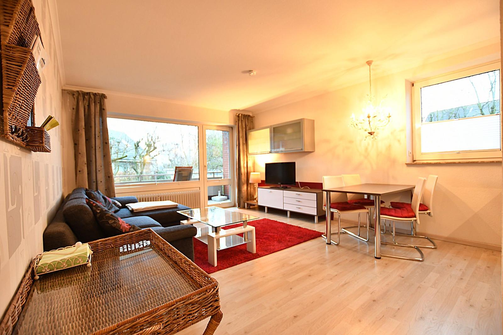 Wohn- und Essbereich mit Sofa, Esstisch und TV.