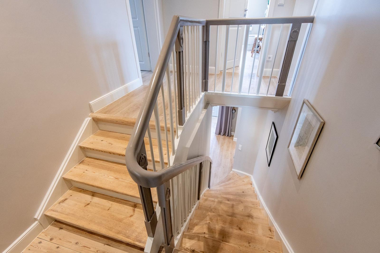 Haus mit Holztreppe und Geländer. Blick in Wohnbereich und untere Etage.