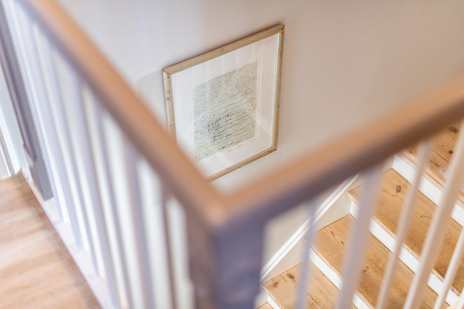 Treppenhaus mit Holzstufen und Wandbild