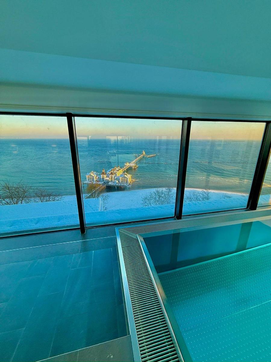 Pool mit Blick auf schneebedeckten See und Pier