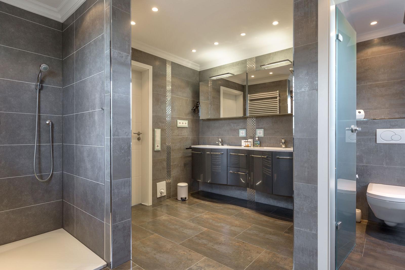 Dusche, Waschbecken und Toilette in moderner Badezimmerausstattung.