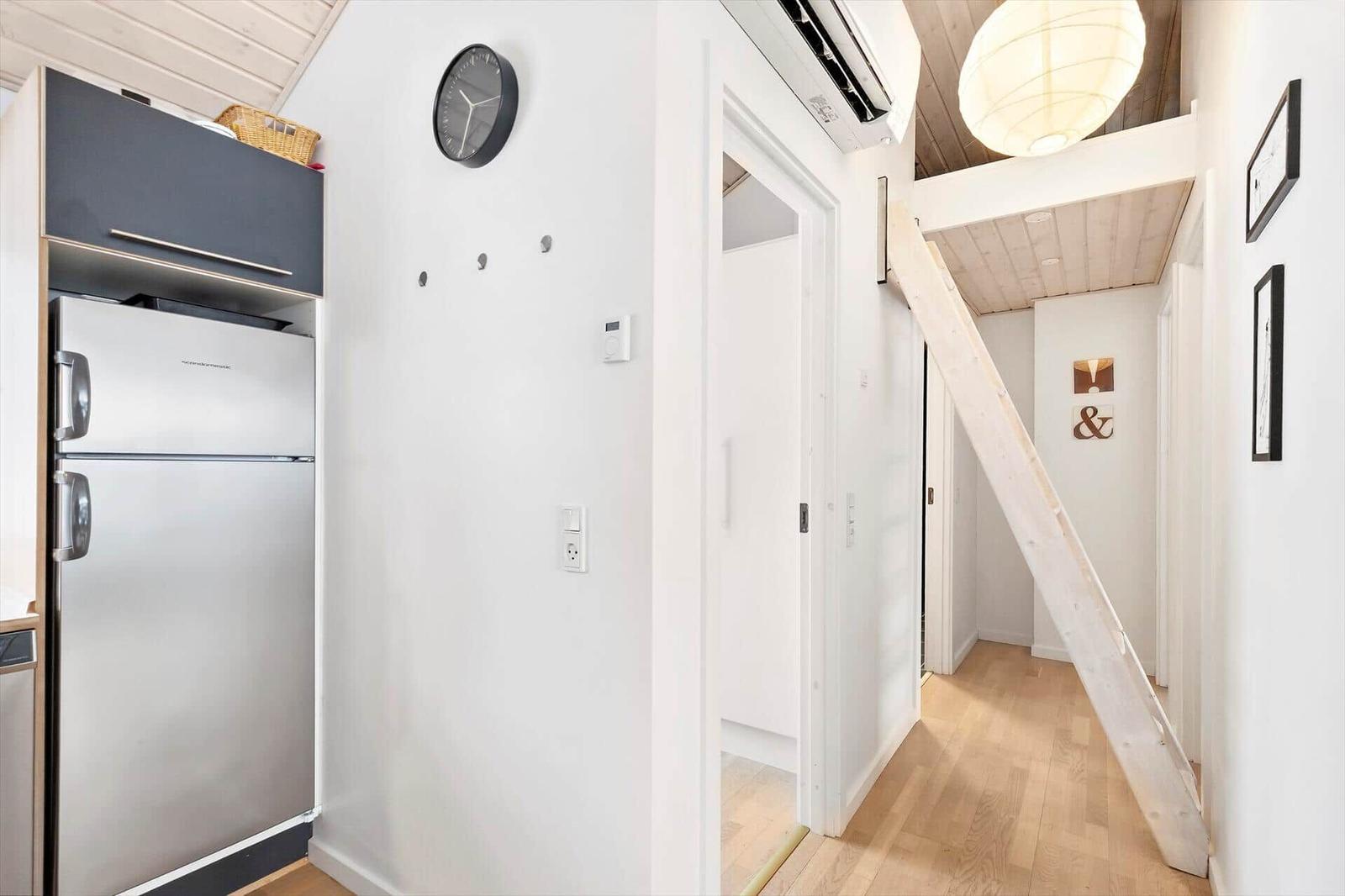 Kitchen with refrigerator and stairs to upper level.
