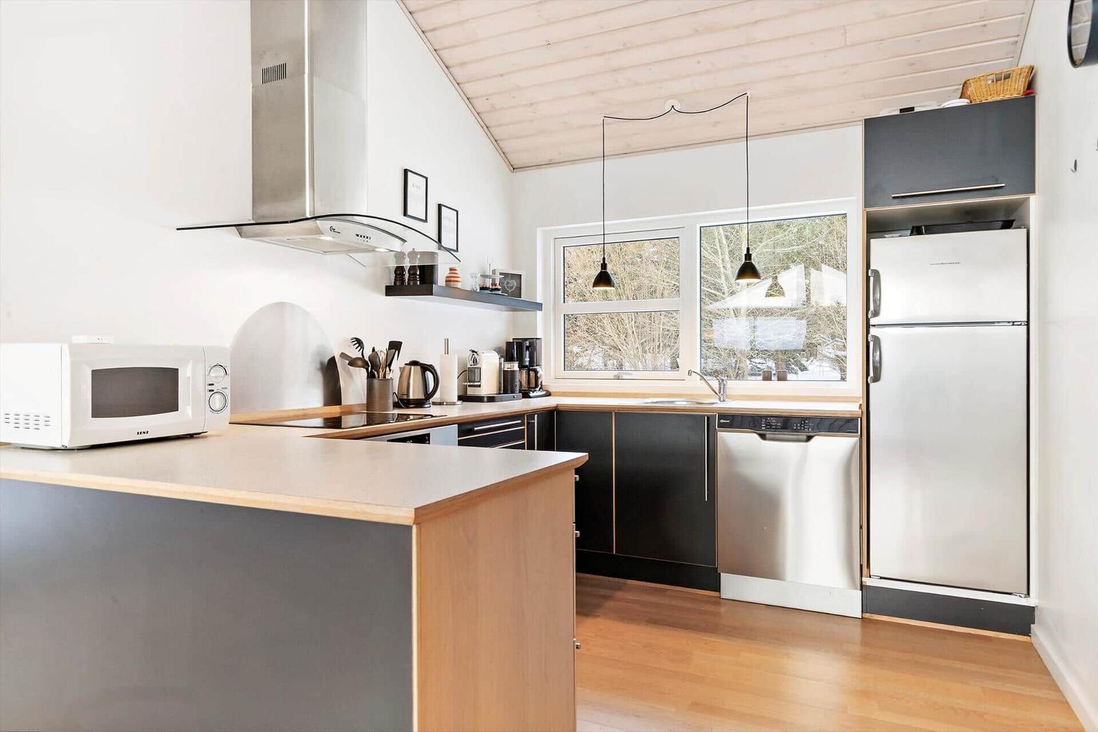 Kitchen with countertop, refrigerator, sink, and window.