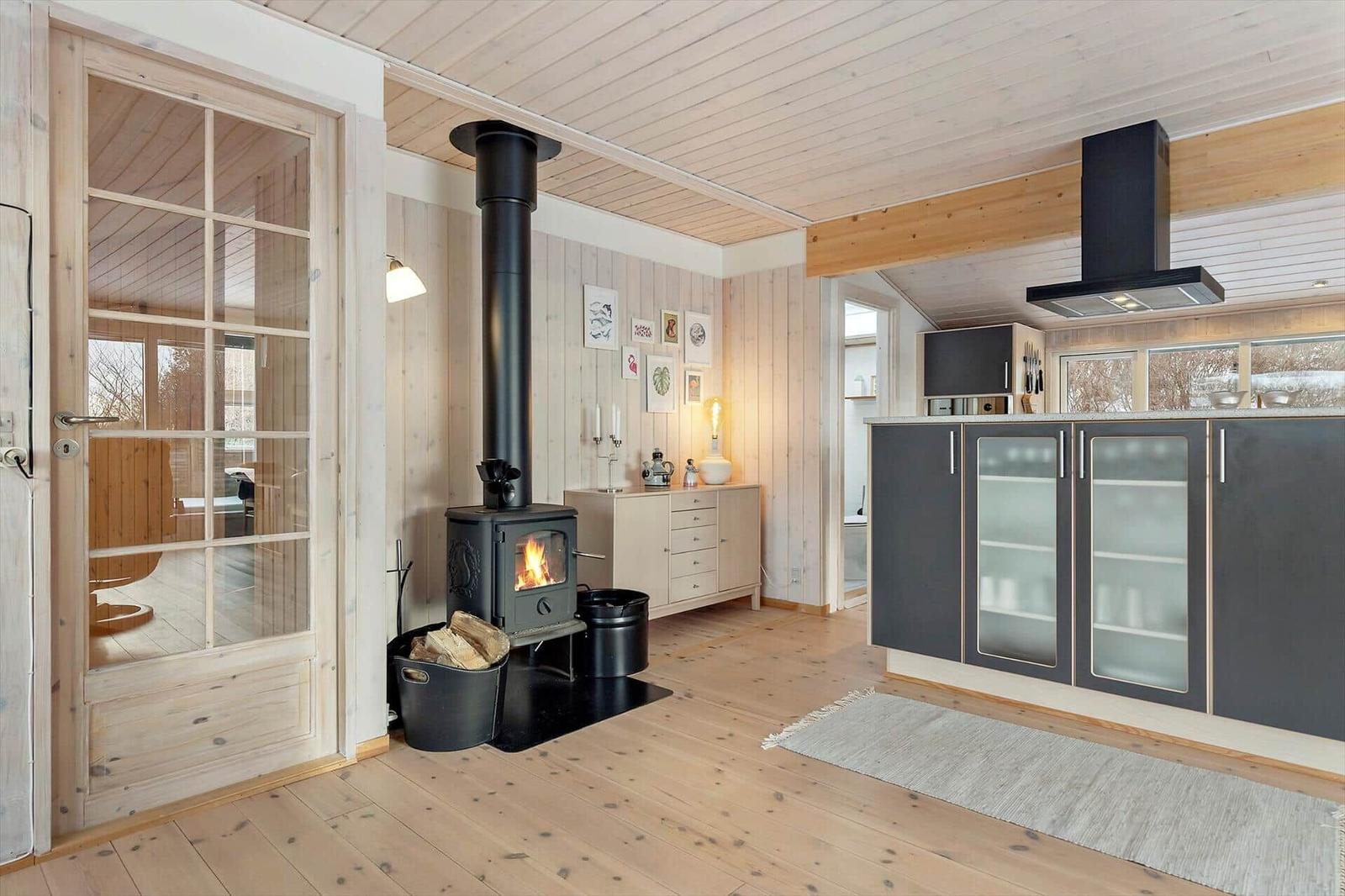 Kitchen with wooden floor and wood-burning stove. Entrance to the bedroom area.