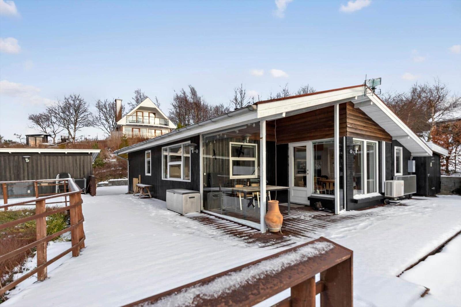 Modern villa with snow-covered yard and large glass area