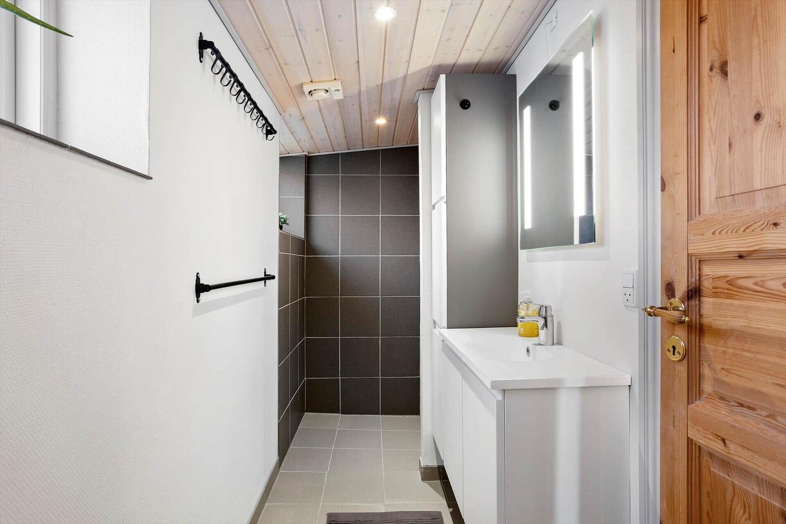 Bathroom with shower, sink, and lit mirror