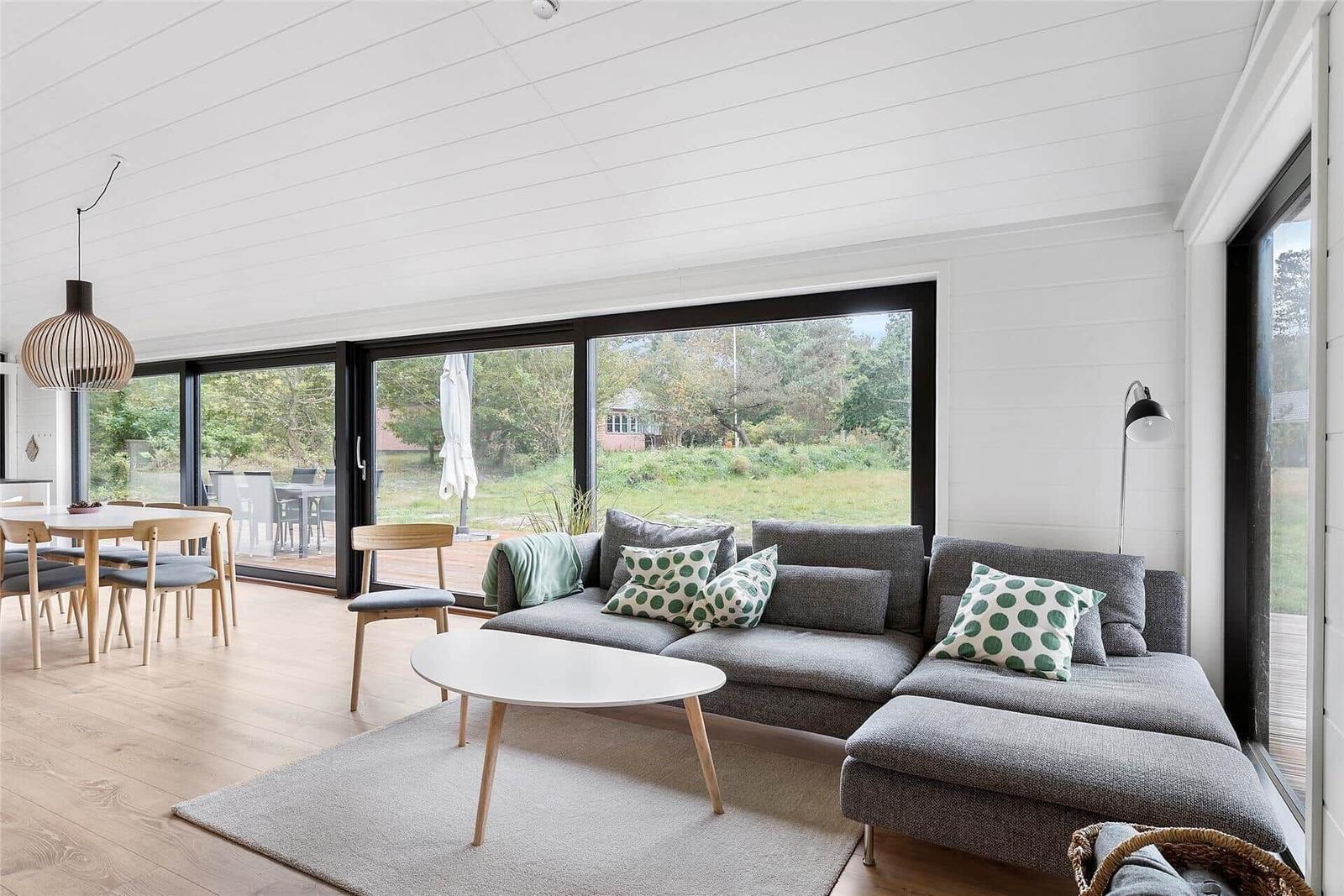 Living and dining area with sofa, table, and view of the terrace.