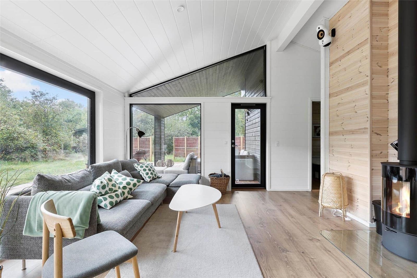 Living room with sofa, fireplace, and large windows for outdoor view.
