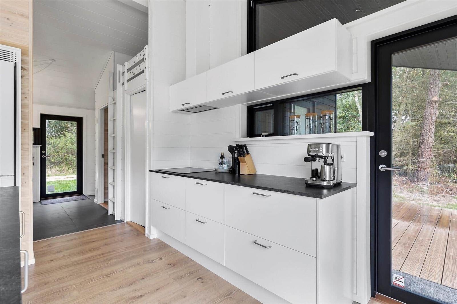 Kitchen with white cabinets, black countertop, and view of terrace
