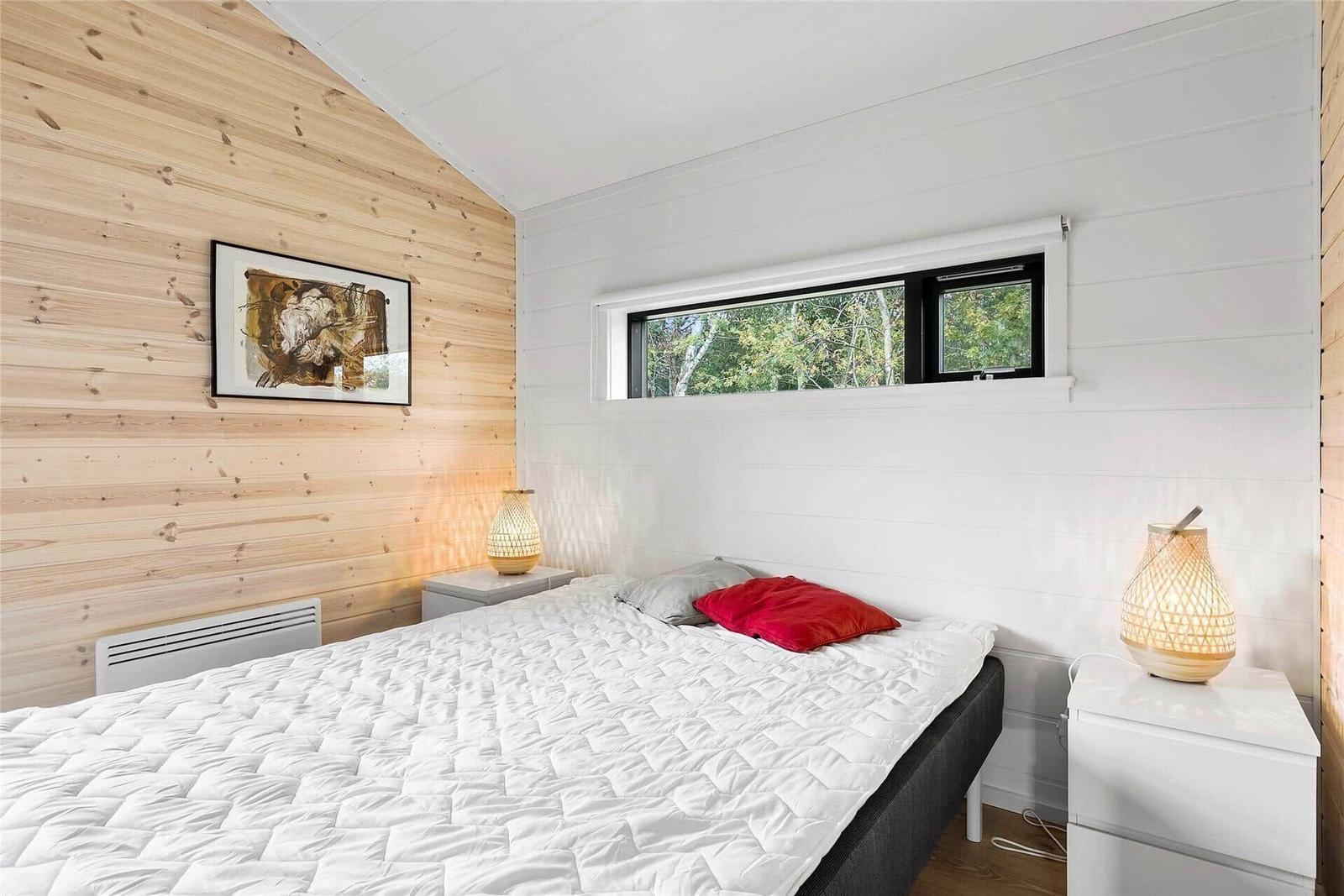 Bedroom with bed, nightstands, and window for views.