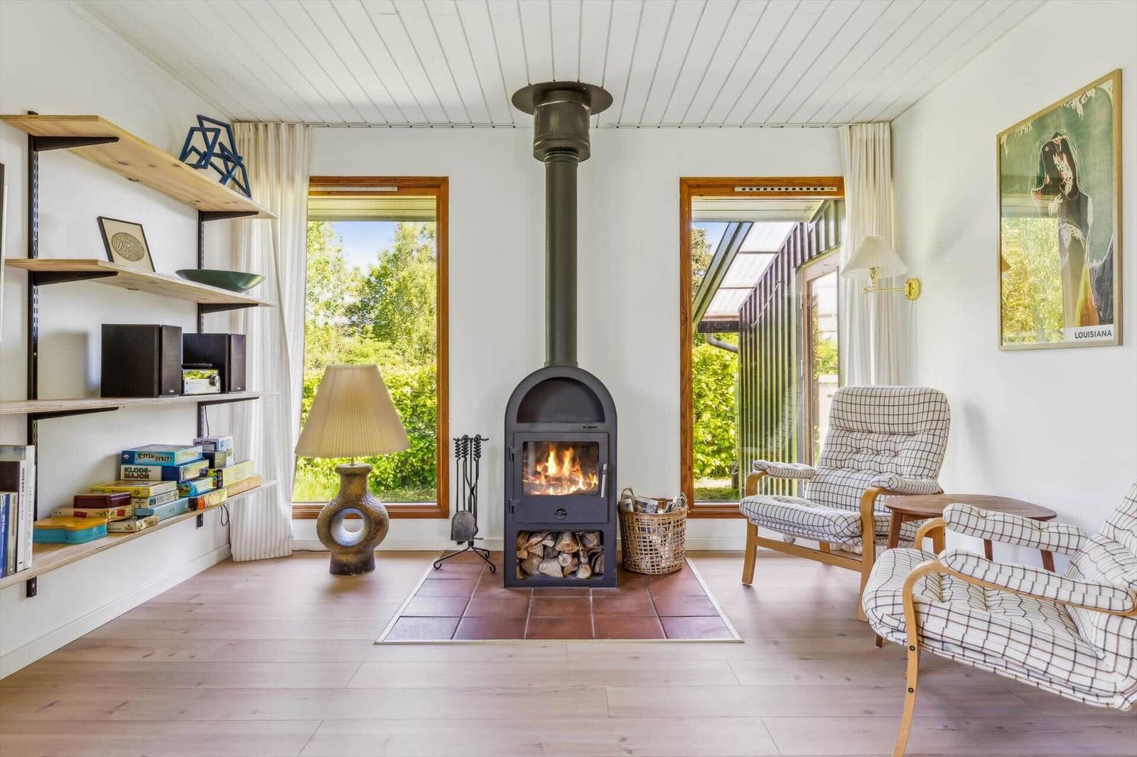Living room with fireplace, seating, and garden view.